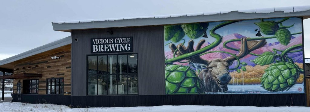 A brewery building with a mural of a moose and hops on its side in Grand County Colorado.