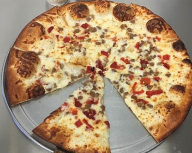 A large cheese pizza with pepperoni and red peppers, one slice missing in Grand County Colorado.