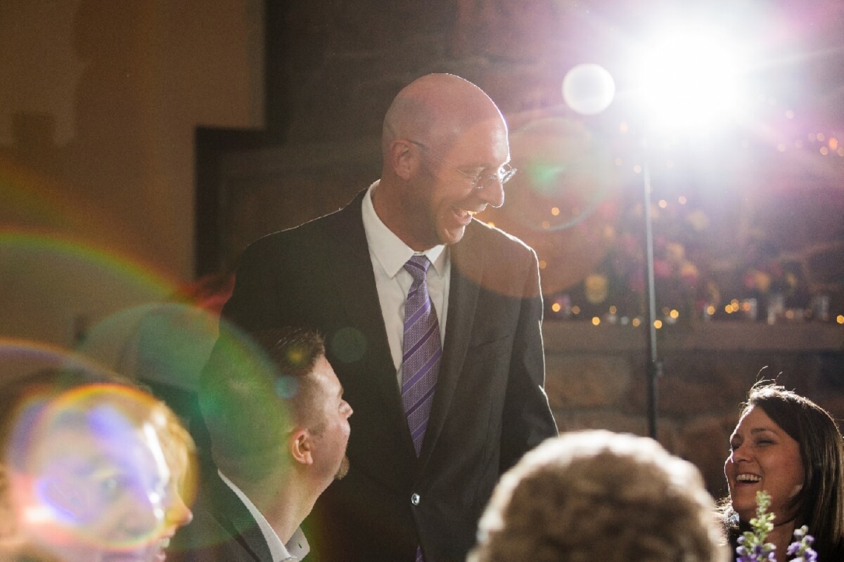 A group of people are gathered in a dimly lit room, laughing and enjoying each other's company in Grand County Colorado.