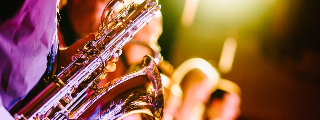 A musician playing a saxophone in a dimly lit performance setting in Grand County Colorado.