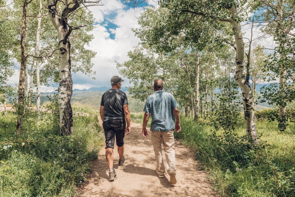 Two people hiking through aspen trees on Columbine Lake Trail.