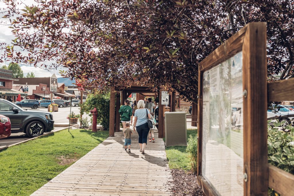 Families walking along the wooden boardwalk in downtown Grand Lake.