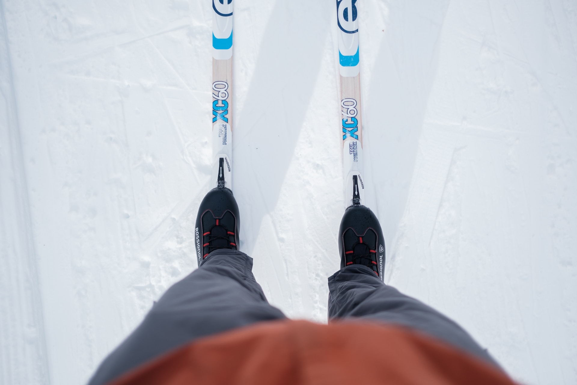 A skier stands on a snowy slope with cross-country skis and poles ready for action in Grand County Colorado.