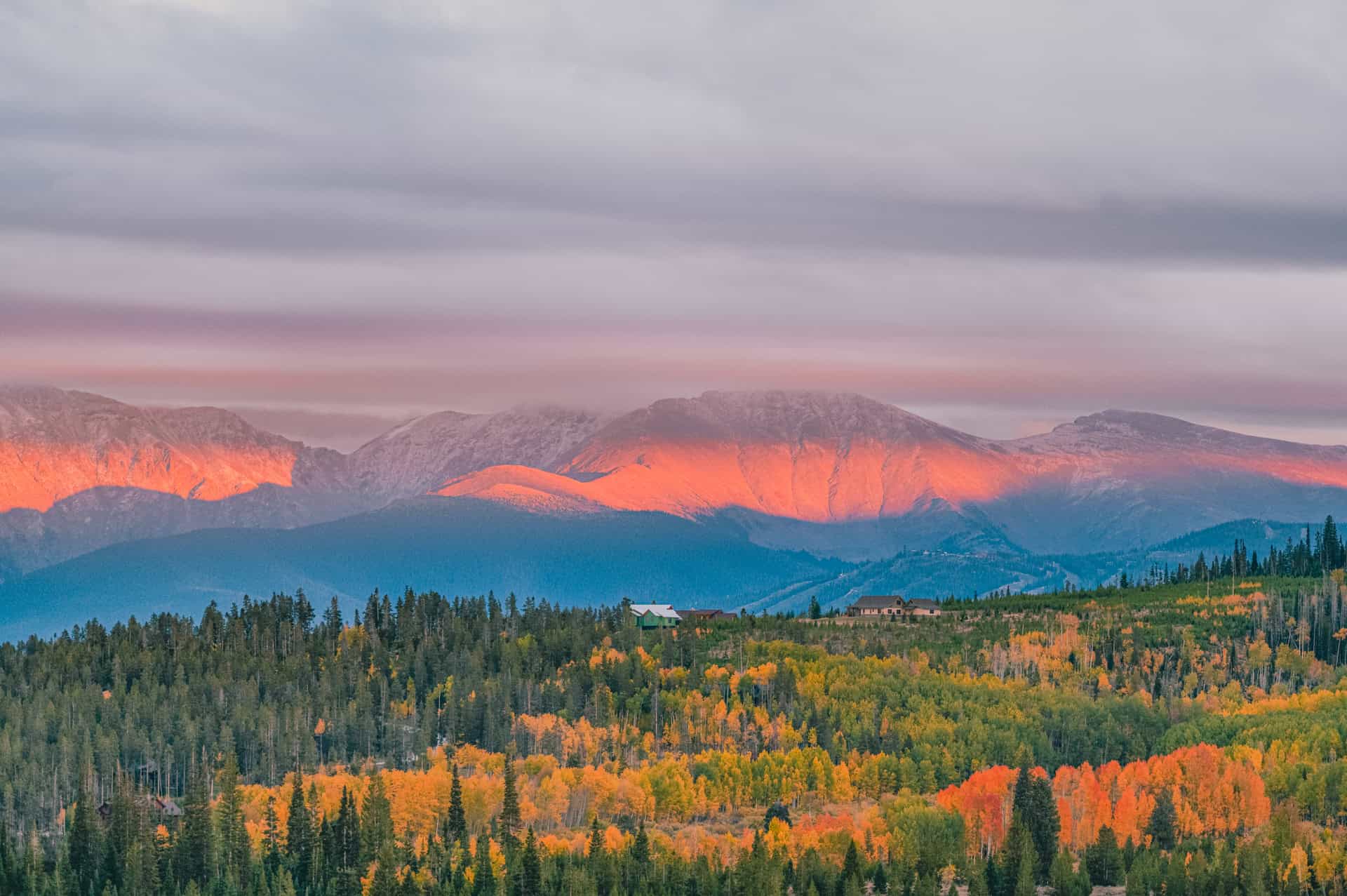 A stunning sunrise over the Rocky Mountains, illuminating the fall foliage and alpine landscape in Rocky Mountain National Park.