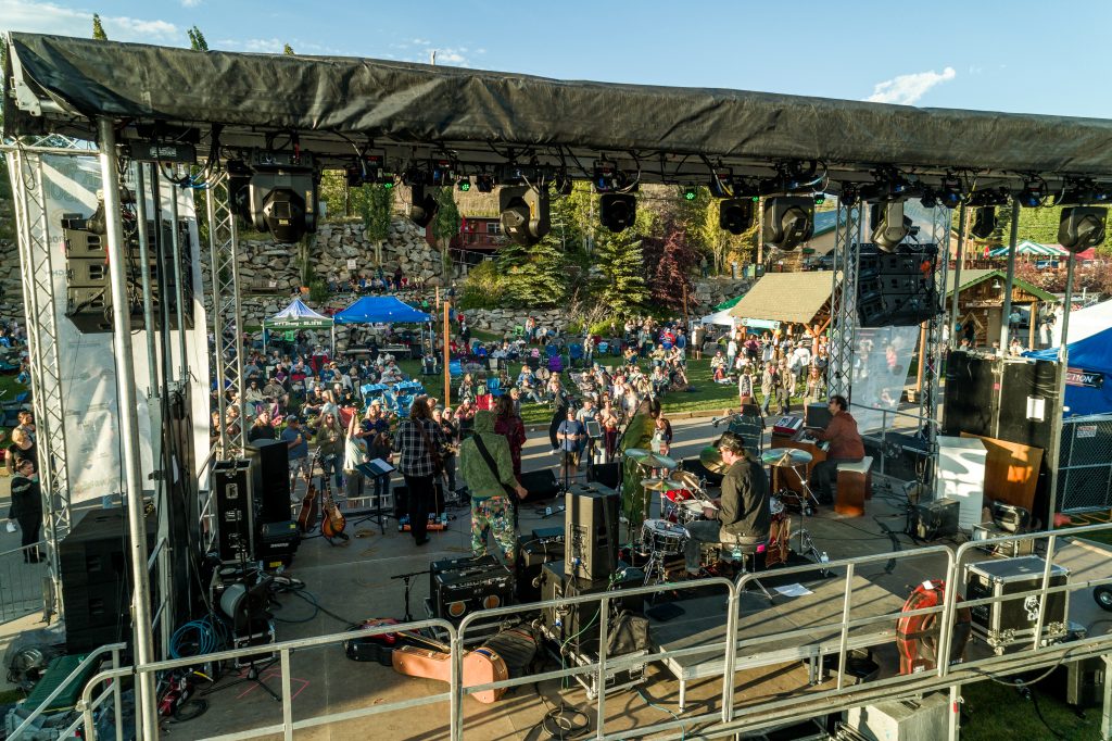 Band performing on stage at Troublesome Fest with a large outdoor crowd.
