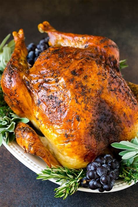 A golden-brown roasted turkey with herbs and grapes on a white plate in Grand County Colorado.