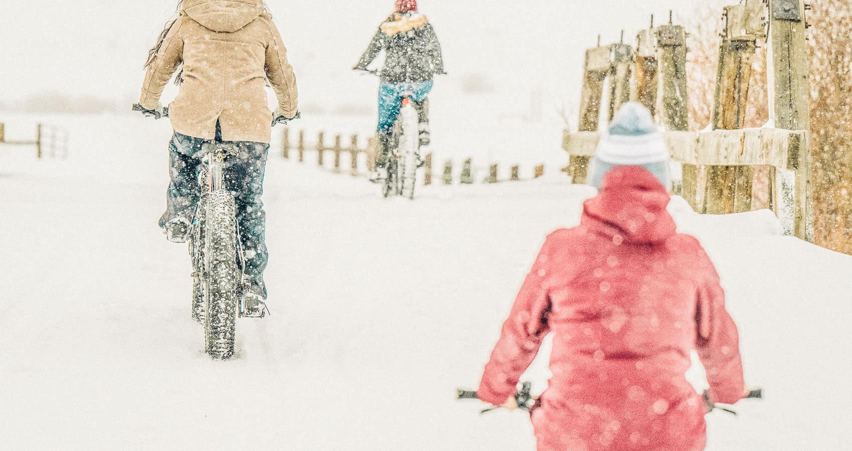 A group of people riding bikes in the snow.