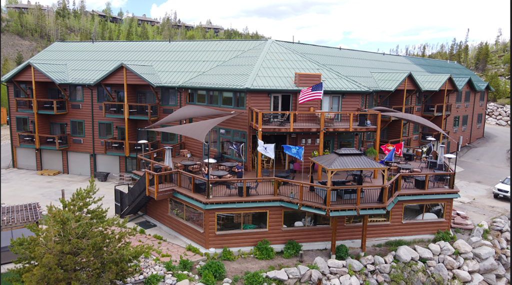 A rustic log cabin resort with multiple balconies and outdoor seating areas in Grand County Colorado.